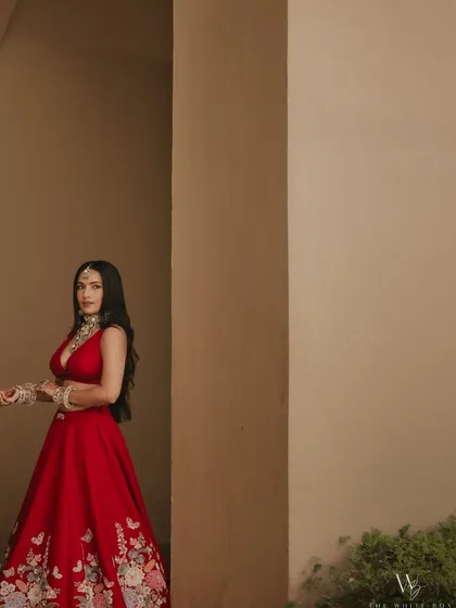 A candid shot showing the beautiful details of Shubhangi's red lehenga and her fresh, dewy makeup.