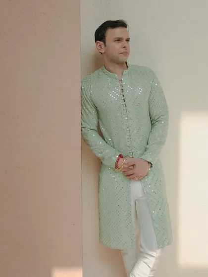 The groom looking dapper in a mint green kurta for his Haldi ceremony. We help coordinate looks that fit the theme and style of the event.