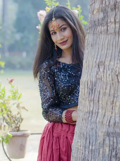 An outdoor fashion-style photoshoot, using natural elements like a tree trunk to create a playful and engaging portrait.