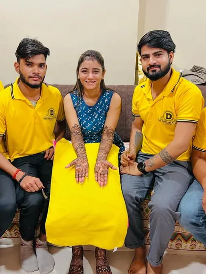 Our artists with a client, showcasing her beautiful bridal mehndi. We ensure every client leaves with a smile.