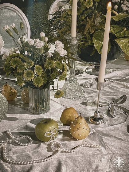 A detail of the tablescape, with pears and apples adorned with pearls, adding a touch of whimsical elegance.