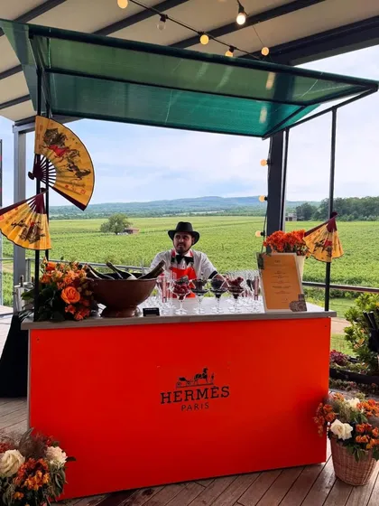 I design high-concept themed bars that bring a brand's essence to life. This vibrant Hermès-themed sundowner bar, set against a beautiful vineyard, offered guests a taste of pure luxury and bespoke cocktails.