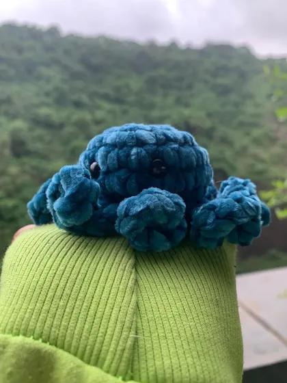 A side view of the velvet octopus amigurumi, showing off its curly tentacles. These plushies are great sensory toys or just cute desk buddies.