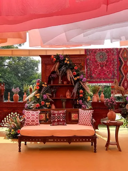 We transport your guests to another world. This seating area from our 'Mocha Magic at the Bazaar' theme uses rich textiles, intricate wooden furniture, and lush florals to create the feel of a luxurious Middle Eastern souk.