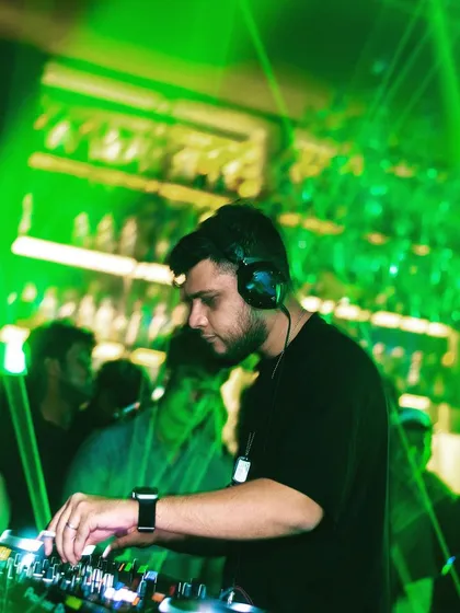 A cool shot of me mixing under green laser lights, highlighting the visual aspect of my shows.