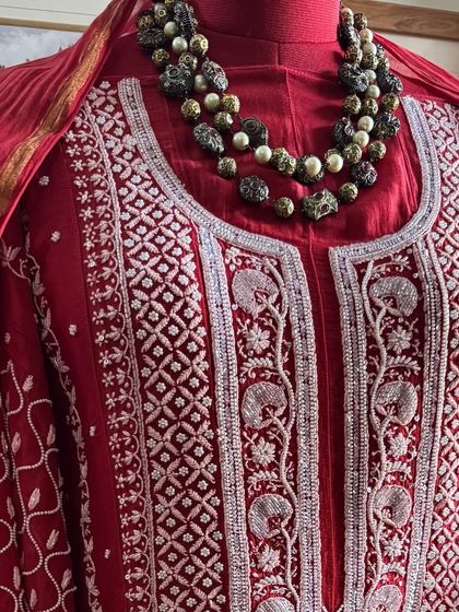 A close-up of the neckline, styled with a statement necklace to demonstrate its versatility for occasion wear.