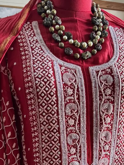 A close-up of the neckline, styled with a statement necklace to demonstrate its versatility for occasion wear.