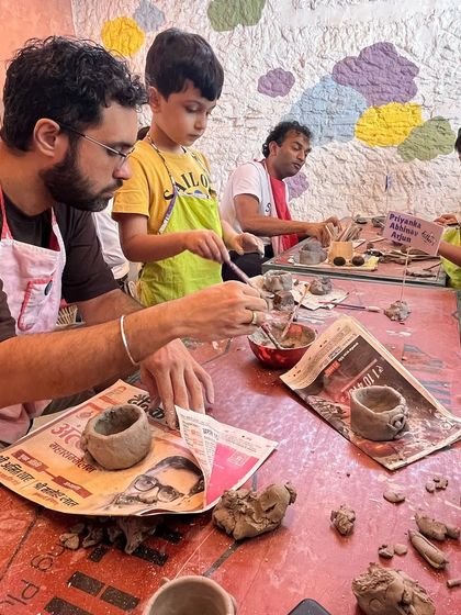 Our workshop tables are a place for collaboration and fun. Here, fathers and sons work together on their clay projects, sharing tools and ideas.