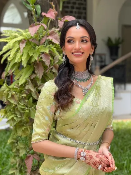 The complete look, featuring a stunning pastel green Kanjeevaram saree. The makeup is subtle, with a neutral eye and soft lip, allowing the saree and jewellery to shine.