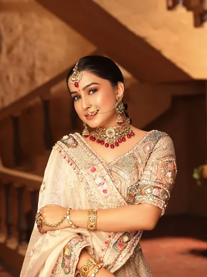 A bridal look is not just about red. This close-up shows the delicate, multi-color threadwork on one of my elegant beige designer lehengas. Paired with a red-beaded choker, it’s a perfect example of a modern yet traditional reception look.