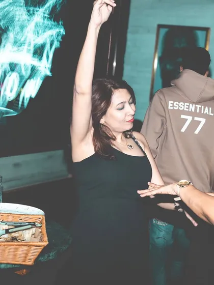 A guest with her hands in the air, completely lost in the music at Mitron.