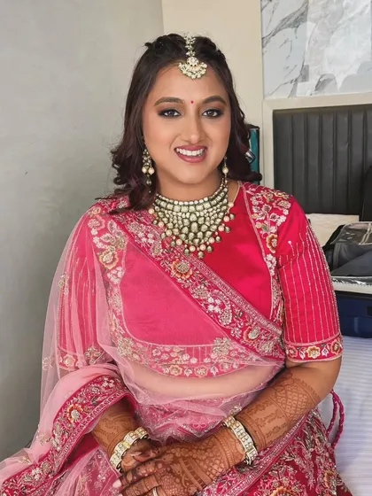 A happy and radiant bride, ready for her big day. The makeup is designed to enhance her natural beauty and last throughout the ceremony.