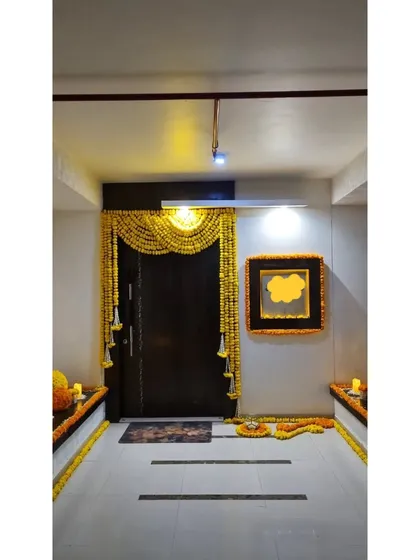 The entryway to a home, ready for a celebration. We framed the door with a traditional marigold toran and decorated the surrounding area with floral arrangements to welcome guests with festive cheer.
