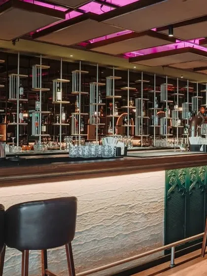 The bar is the centerpiece of this Hennur resto-bar project. I designed a dramatic, suspended display for the bottles, which becomes a sculptural element. The combination of warm wood, custom lighting, and comfortable seating creates a sophisticated and inviting atmosphere for guests.
