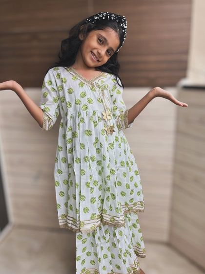 Fresh and breezy, this angarkha set features a lovely green leaf print on a white base. The gold trim and playful tassel make it a perfect outfit for any festive or casual occasion.
