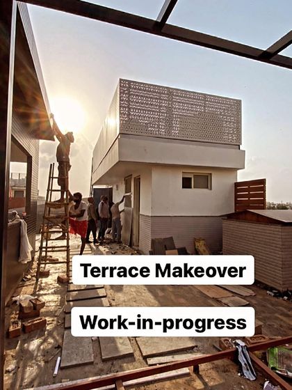 A dramatic shot of a terrace makeover in progress as the sun sets. Our team works diligently to install facade elements and prepare the site for the next phase of construction.
