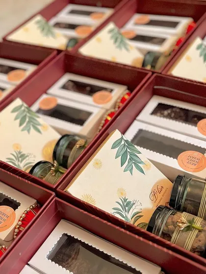 The contents of our premium Diwali hamper, including boxes of brownies and jars of nuts, all neatly arranged.