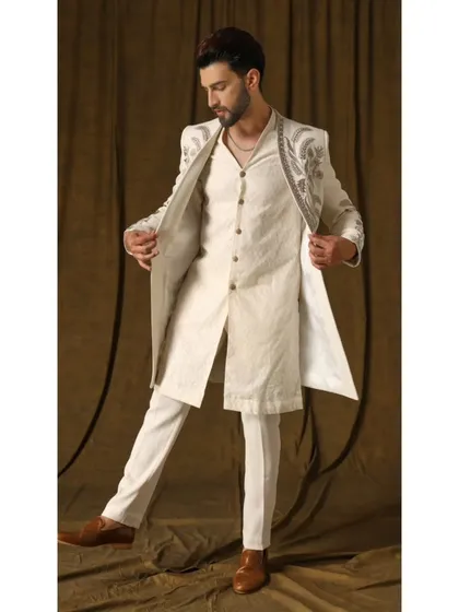 Layering is an art form. This Indo-Western ensemble features an intricately embroidered open-front shrug over a handwoven geometric pattern kurta. The ivory-on-ivory palette creates a look of pure sophistication, ideal for the modern man.