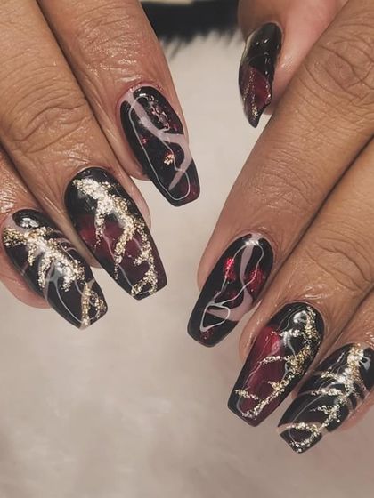 A dark and dramatic design with intricate details. This set features a black and deep red base with abstract swirls of white and sparkling silver glitter.