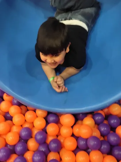 A big smile from a boy enjoying our blue tube slide. I designed the play area to be full of bright colors and exciting structures to spark joy and imagination.