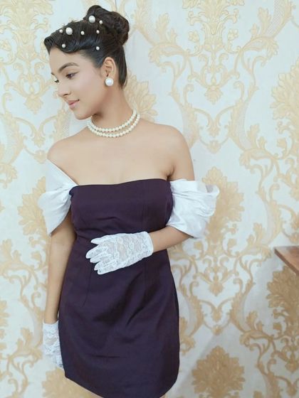 A full shot from the vintage editorial, showing how the hairstyle works with the complete look. The classic updo, paired with a pearl necklace and lace gloves, creates a cohesive and elegant retro-inspired character.