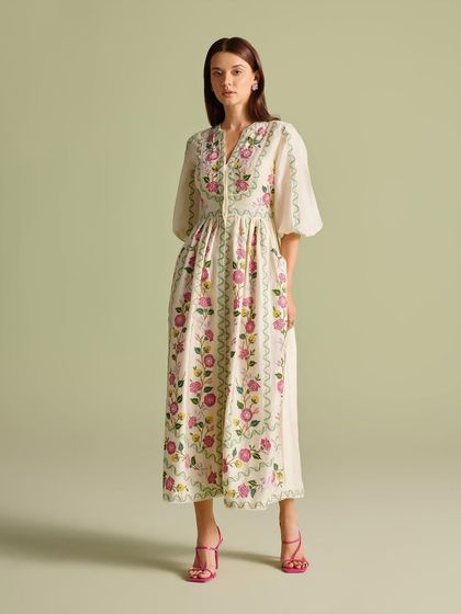 A model showcases the full silhouette of the pink floral embroidered dress, a perfect picture of feminine grace.