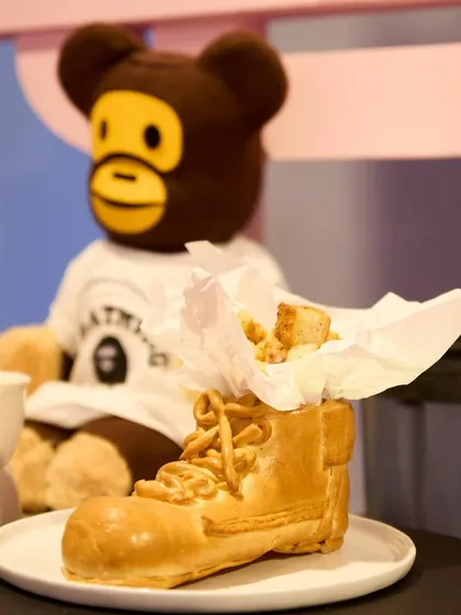 Another view of our sneaker-shaped bread, this time paired with a BAPE teddy bear, highlighting the playful intersection of streetwear culture and food.