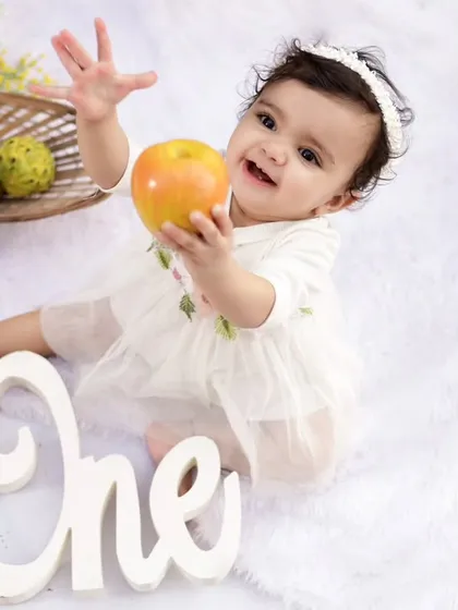A simple and sweet fruit-themed outdoor shoot. Using natural props like apples and lemons adds a fresh and organic feel to first birthday photos.