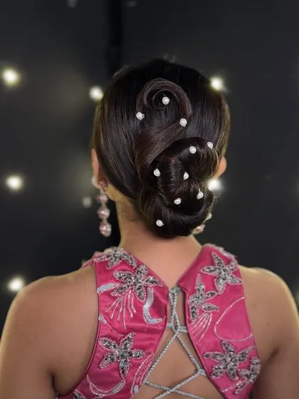 Creating elegant updos is a core skill. Here is a clean, structured bun with delicate pearl accessories, showcasing the precision and artistry you will learn to master for bridal and formal events.