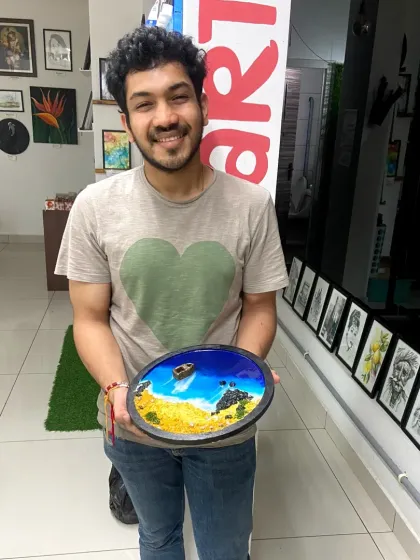 A participant proudly holds up his finished resin beach art. The sense of accomplishment after creating your own artwork is unbeatable.