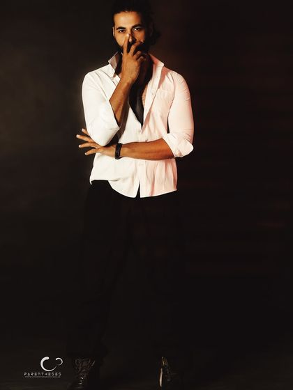 A gesture of silence and thought. This low-key portrait uses shadow to create a mysterious and compelling narrative, leaving the viewer to wonder about his story.