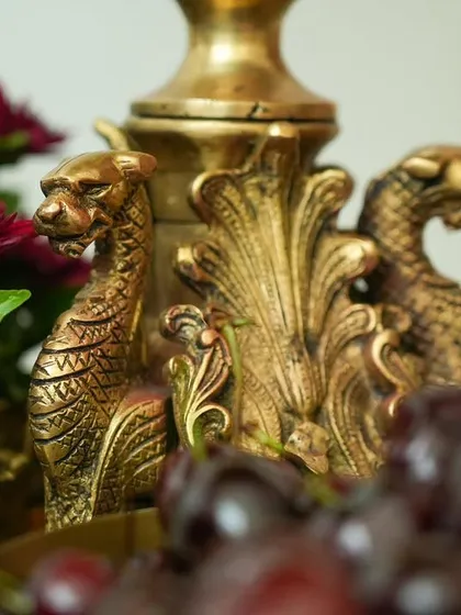 The same brass prop, showing how it's integrated into the tablescape with deep red chrysanthemums and fresh cherries.