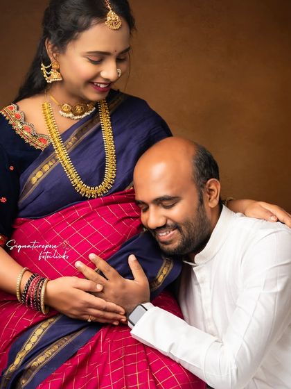 This close-up captures the pure joy and connection, highlighting the beautiful details of the saree and jewelry.