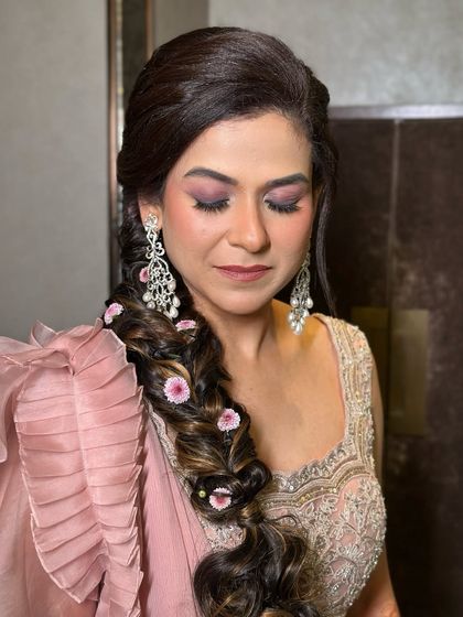 A close-up of this bride's dewy makeup, with a focus on the purple smokey eye and her floral braid.
