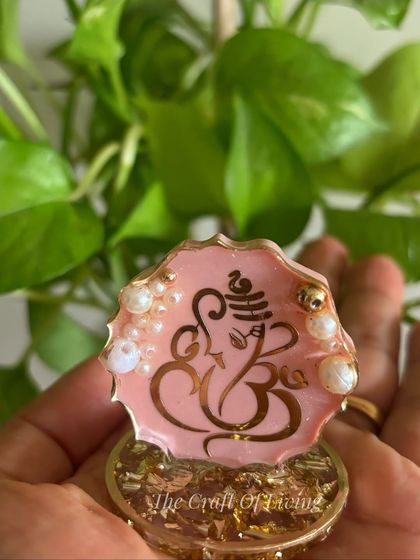 A lovely pink Ganesha standee with a gold base. These small, handcrafted pieces are perfect for adding a touch of divinity to any space.