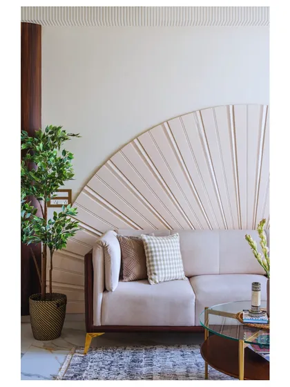 The living room of 'Apartment 601' is all about warm tones and lush greenery. The fan-like detail behind the sofa adds a unique, sculptural element to the space.