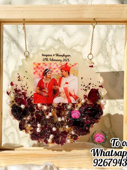 This hanging decorative plaque is a beautiful way to display your wedding memories. The preserved flower piece hangs within a wooden frame, creating a lovely shadow box effect.