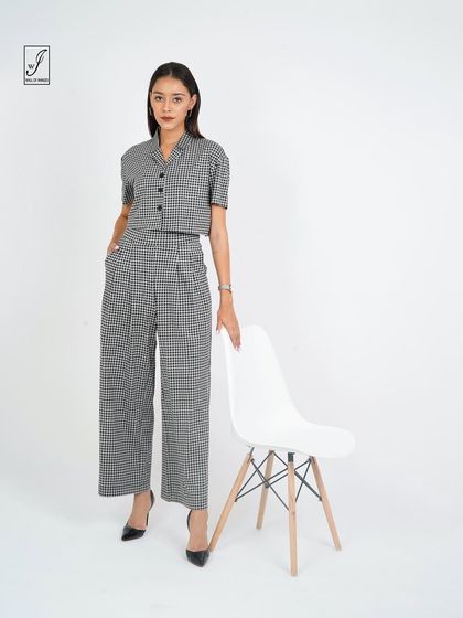 A sophisticated co-ord set in a checkered pattern, styled with a modern chair for a clean, minimalist look.