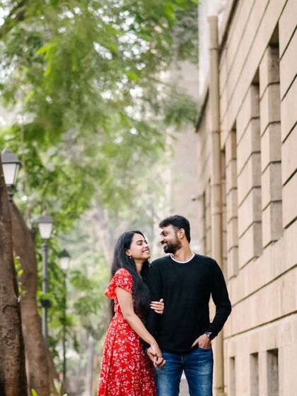 A casual stroll down a tree-lined city street. This is a perfect example of a candid couple portrait where the focus is on their natural interaction and movement.
