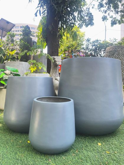 A trio of my modern, grey, rounded planters in various sizes, perfect for creating a cohesive cluster on a lawn or patio.