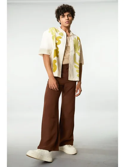 A full-length shot of the artistic shirt look. The hair and makeup are understated to balance the bold, abstract design of the clothing.