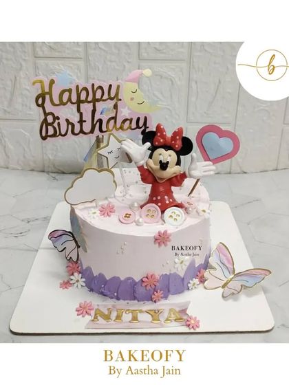 A dreamy baby pink cake for a 2nd birthday. This fresh fruit cake features Minnie Mouse, stars, clouds, and butterflies for a sweet celebration.