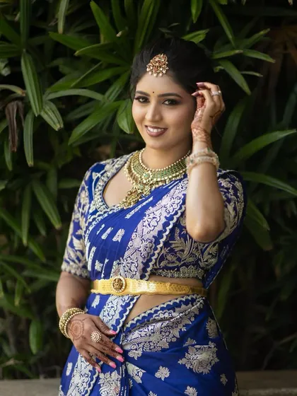 A duplicate of image 113, a close-up of the bride in her royal blue saree and custom blouse.