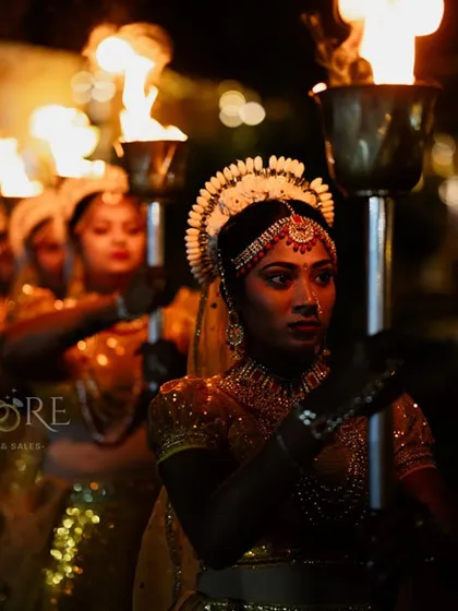 Making an entrance that nobody will forget. We coordinate with performers to create dramatic and theatrical moments, like this aisle welcome with traditionally dressed dancers holding torches, ensuring a grand and memorable start to the celebration.
