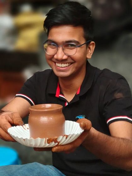 A participant from our corporate workshop proudly displays the pot he made on the wheel. Our events are designed to be accessible and enjoyable for all skill levels.