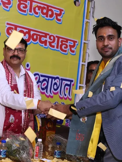 Receiving a token of appreciation at the Ahilyabai Holkar Jayanti event, complete with a celebratory shower of petals.