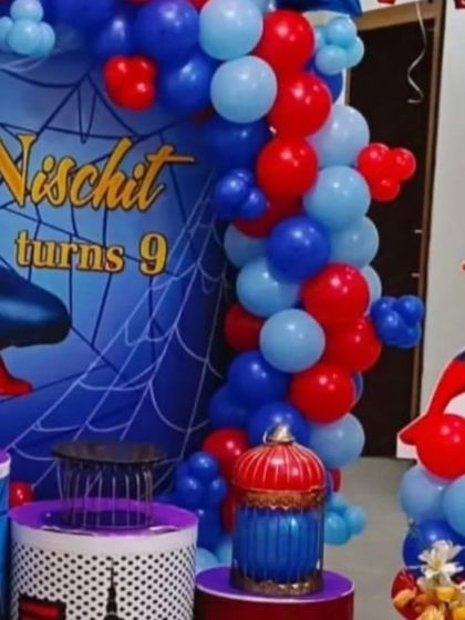 For superhero fans, I offer themes like this Spiderman setup. It includes a custom backdrop with the birthday boy's name and age, a red and blue balloon garland, and a Spiderman character prop.