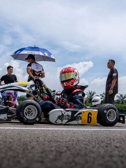 Our team provides shade for a driver on the grid, managing every detail to ensure they are comfortable and focused.