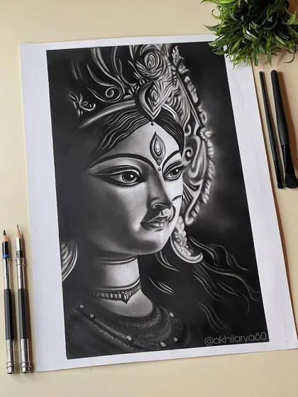 The divine feminine power of Maa Durga, captured in a striking charcoal drawing. The deep blacks and subtle highlights bring out her intense yet compassionate expression.