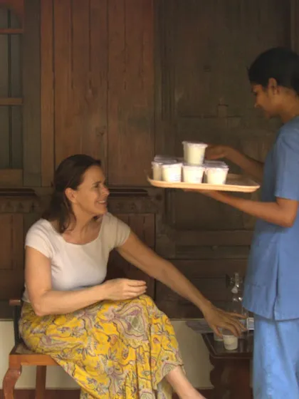 Healing with a smile. A therapist serves a guest her prescribed herbal medicine with warmth and care. We believe that a positive and caring attitude is an essential ingredient in the healing process.